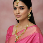 Woman in a pink saree with gold jewelry against a pink background
