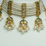 Pearl necklace with gold and green accents on a white background